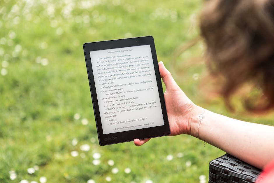 A person holding an eBook reader with a bright screen, symbolizing eBook marketing and digital reading.