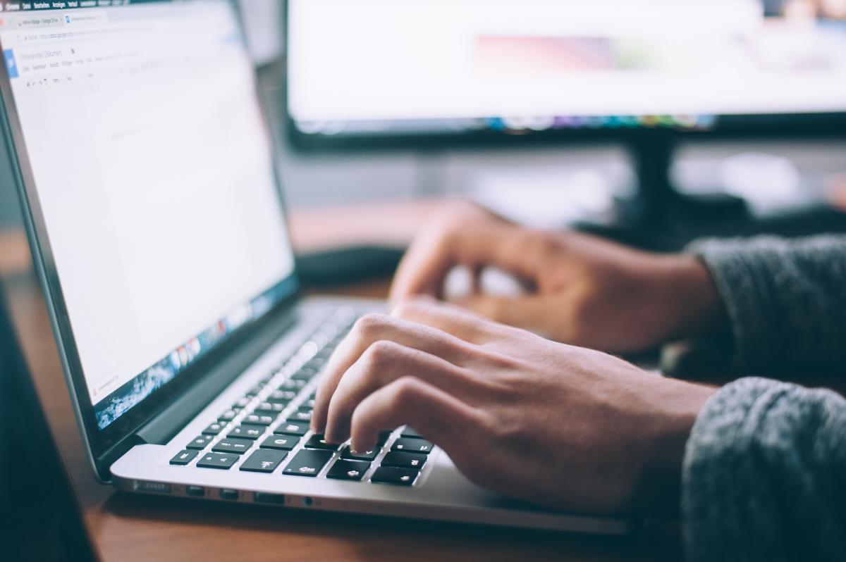 Image of a person working on a laptop with various side hustle icons around them